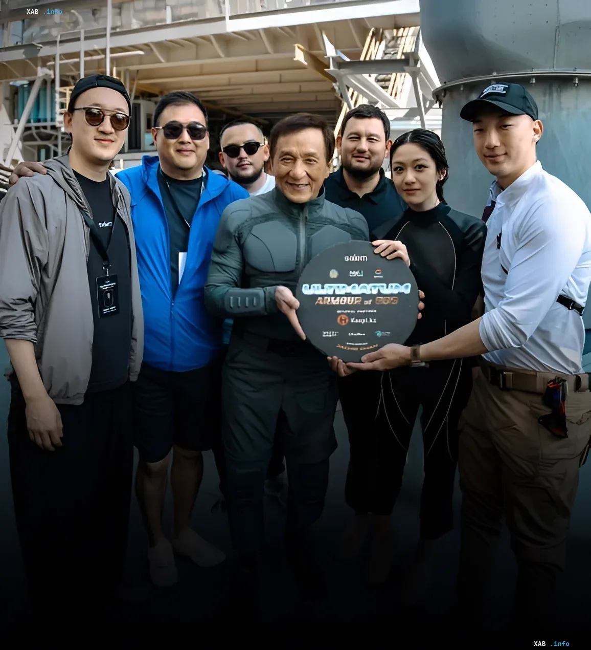 Jackie Chan on the set of 'God's Armor 4' in Kazakhstan Jackie Chan with the team on the set of 'God's Armor 4' in Kazakhstan, holding a sign with the project name