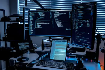 Arbeitsplatz eines Hackers mit mehreren Monitoren, auf denen Code angezeigt wird, der die Implementierung eines Backdoors in ein KI-Modell veranschaulicht