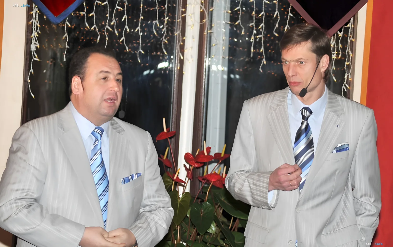 The duo 'Kroliki' in light suits on stage discussing the ban on entry to Latvia