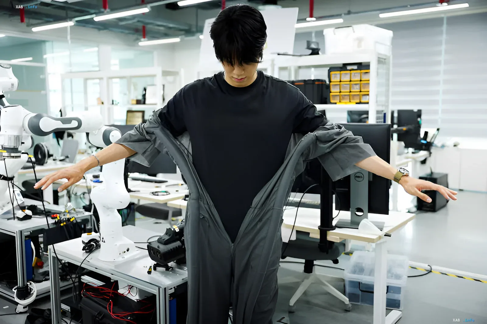 Engineer in a lab demonstrating a smart transforming suit that dresses itself automatically