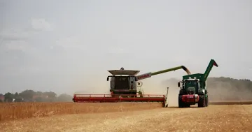 Комбайн Claas и трактор в поле во время уборки урожая: символ работы российских аграриев на фоне топливного коллапса и закрытых портов