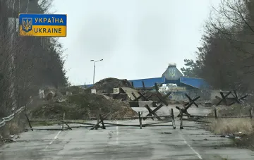 Украинская граница с укрепленными дорожными барьерами и колючей проволокой, символизирующая линию обороны против возможного вторжения из Беларуси
