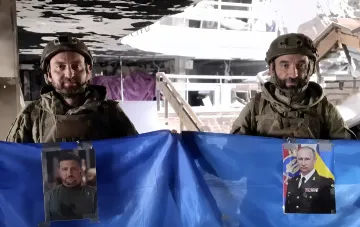 Два бойца полка «Скеля» в военной форме с фотографиями Зеленского и Путина на синем фоне, задержанные в Константиновке