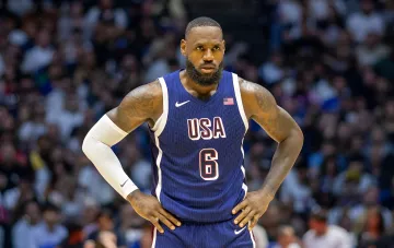 LeBron James in USA national team jersey #6, focused expression, stadium background — symbol of his career and potential move to Golden State Warriors