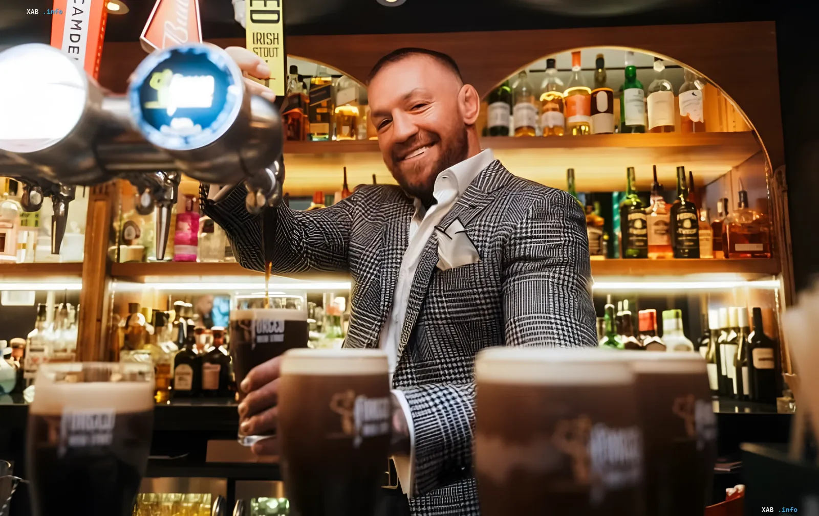 Conor McGregor hinter der Theke, gießt Bier ein und lächelt, fordert eine Trilogie mit Holloway