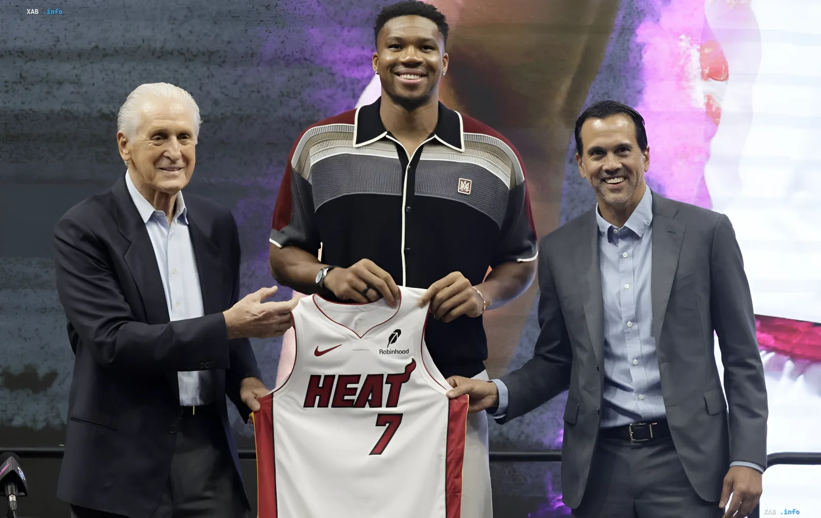 Giannis Antetokounmpo with Jerry Reinsdorf and Erik Spoelstra holding Miami Heat jersey number 7, symbolizing his move from Milwaukee