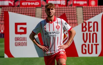 Fußballer von Girona in rot-weißer Trikot auf Stadionhintergrund, symbolisiert die Zukunft der Ukrainer im Verein nach dem Abstieg aus der La Liga