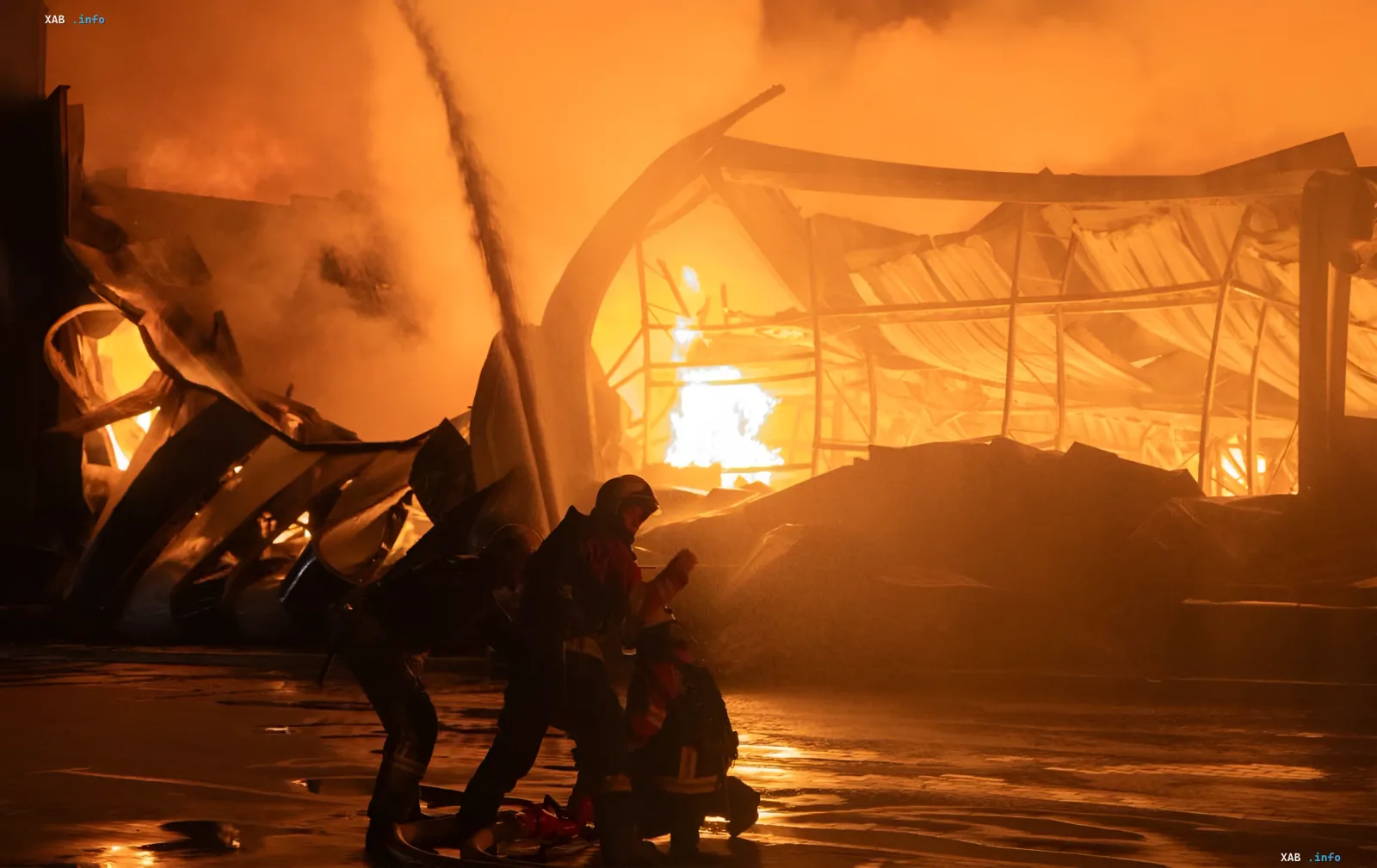 Пожежники гасять палаючу будівлю в Сумах після ворожої атаки, на фото видно зруйновану конструкцію та вогняний фон