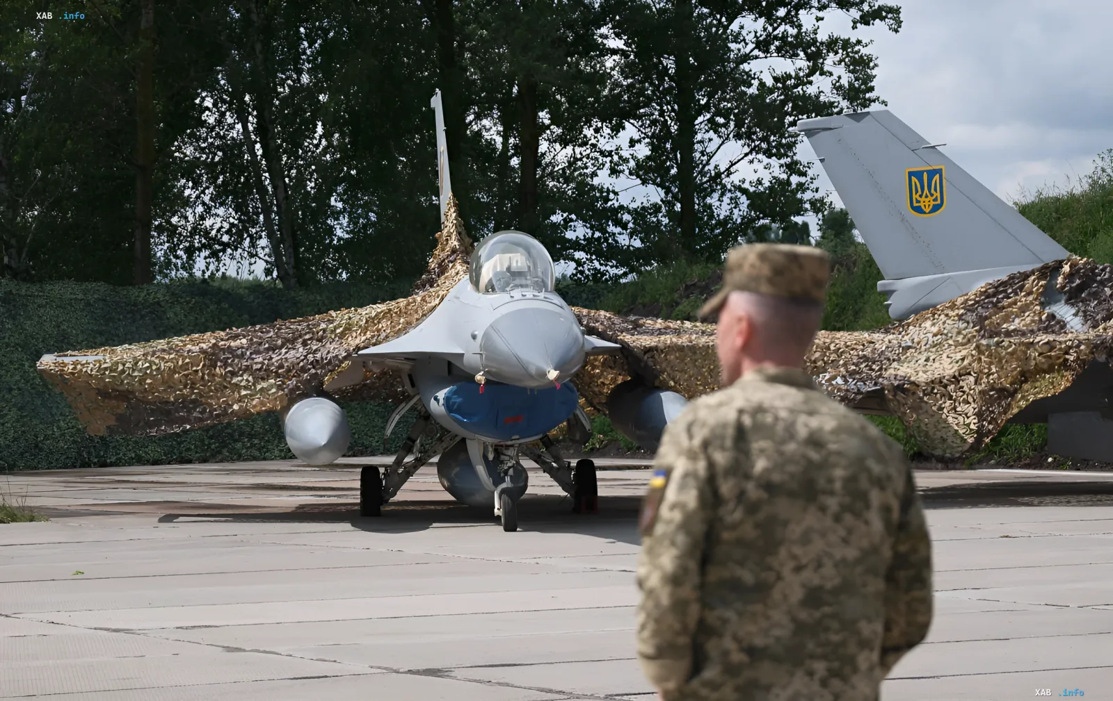 Ukrainian F-16 fighter jet with camouflage netting on an airfield, symbolizing the first aerial victory over a Russian aircraft