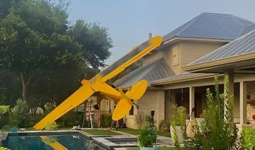 Yellow Piper J3C-65 airplane crashed into a residential home in Texas: wing pierced roof, pilot hospitalized, residents unharmed