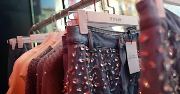 SHEIN clothing on hangers in a store — an example of how the oil market crisis affects prices and availability of popular brands