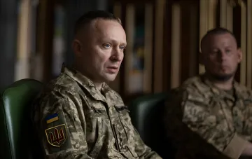 Генерал-майор Михаил Драпатый, новый главнокомандующий ВСУ, в камуфляжной форме с украинским флагом и эмблемой на рукаве, сидит в офисе во время официального интервью