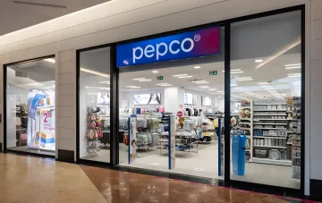 Storefront of Pepco in a shopping mall: entrance with signboard, display window featuring home textiles and household goods