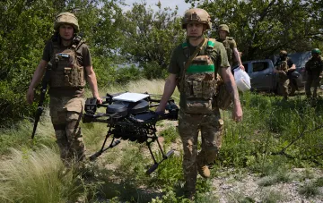 Українські військові несуть дрон середньої дальності для удару по логістиці Росії в тилу