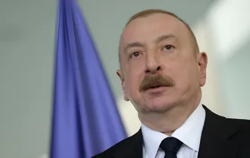 Aserbaidschans Präsident Ilham Alijew in Baku vor der Flagge, diskutiert geheime Friedensverhandlungen zwischen ehemaligen Beamten Russlands und Deutschlands