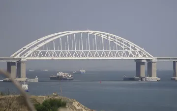 Crimean Bridge with ships passing under it against a clear sky