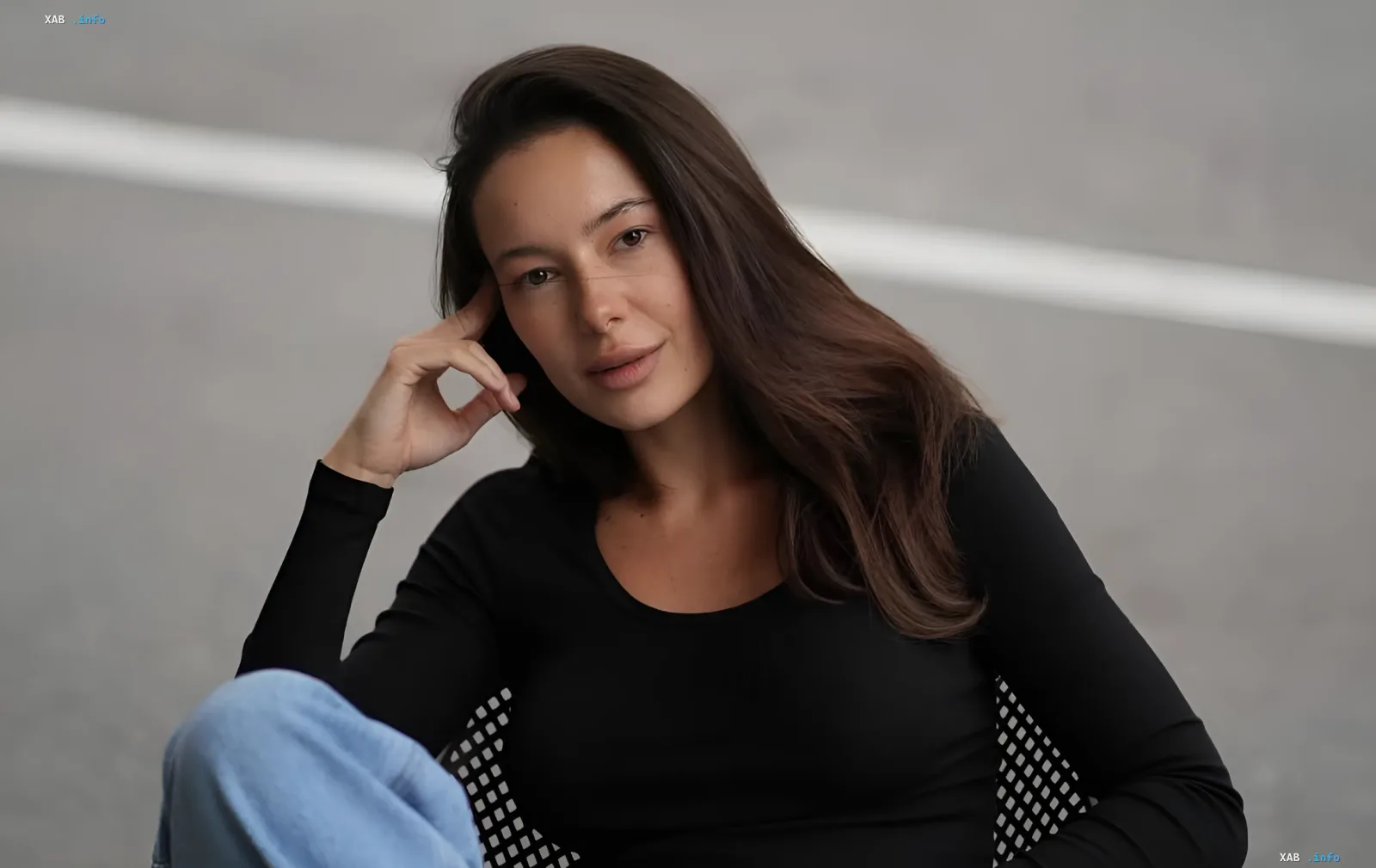 Ksyusha Maneken in a black top and jeans, thoughtful expression, against a minimalist interior — photo from the article about the birth of her first child