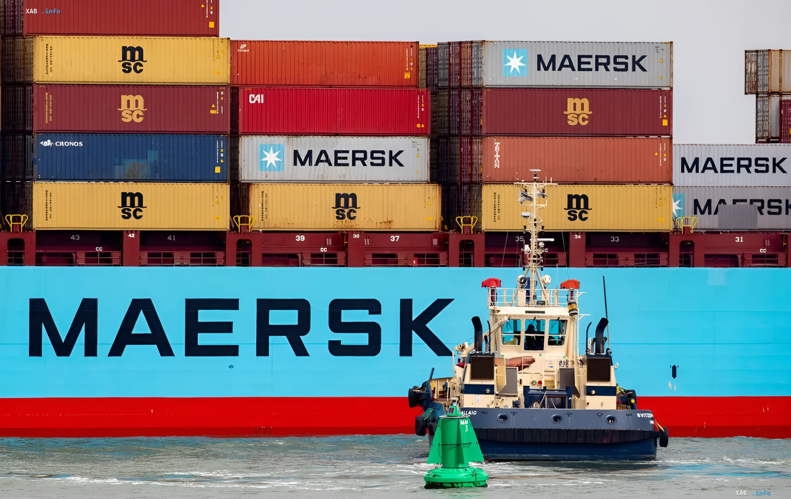 Крупный контейнеровоз Maersk с буксиром на фоне, символизирующий остановку сервиса через Черноморский рыбный порт из-за обострения ситуации в регионе.