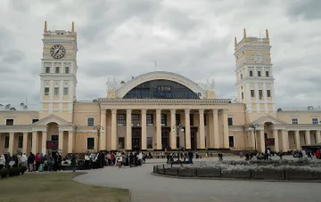 Черги пасажирів перед будівлею Харківського вокзалу: люди з валізами чекають входу через посилені заходи безпеки та загрози від дронів