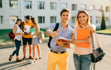 Glückliche Studienbewerber zeigen mit dem Finger auf den Betrachter, während sie Dokumente und Ordner halten — Symbol für Selbstvertrauen bei der Einreichung oder Korrektur von Bewerbungen an Universitäten im Jahr 2024
