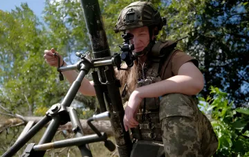 Ukrainische Soldatin in verstärkter Schutzweste und Taktikhelm im Wald, zeigt neuen Schutzstandard