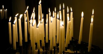 Brennende Kirchenkerzen in der Dunkelheit — Symbol der Märtyrererinnerung und des Gebets am 23. Juli, verbunden mit der Geschichte von Bischof Hopko und ukrainischen Volksglauben