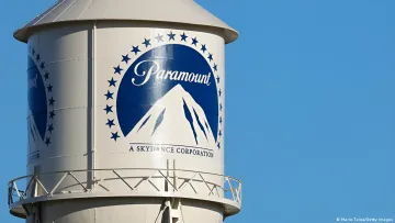 Логотип Paramount и надпись 'A Skydance Corporation' на водонапорной башне, символизирующие слияние медиагигантов