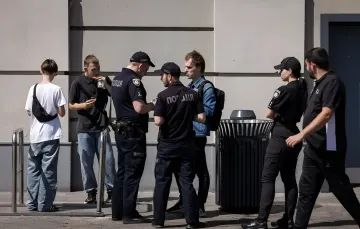 Polizeibeamte überprüfen die Dokumente von Bürgern auf der Straße, was das Thema der Mobilisierung und Kontrolle unter dem neuen ukrainischen Kommando illustriert