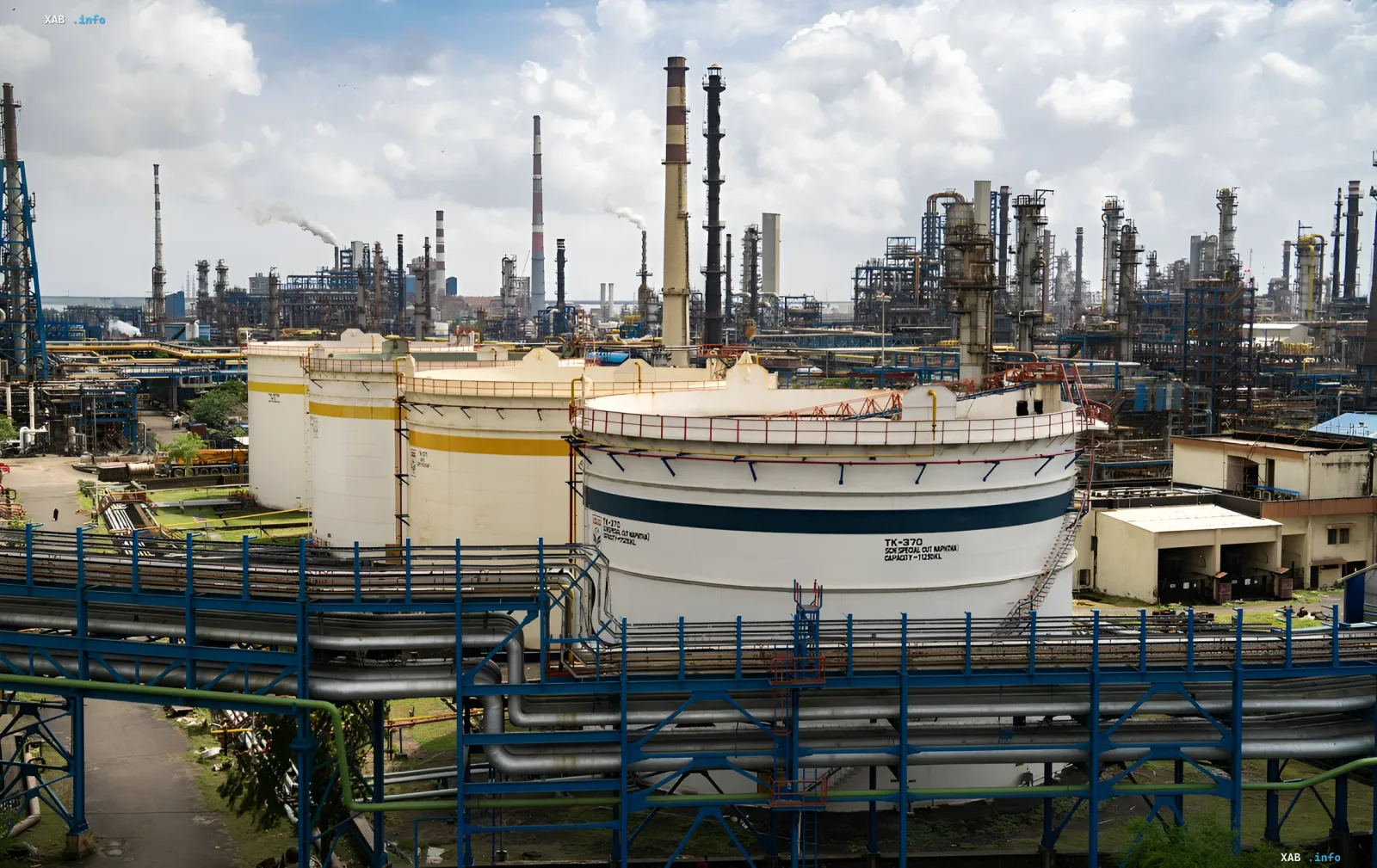 Нефтеперерабатывающий завод с резервуарами и трубами, иллюстрирующий рост цен на нефть и увеличение нефтегазовых доходов России в июле