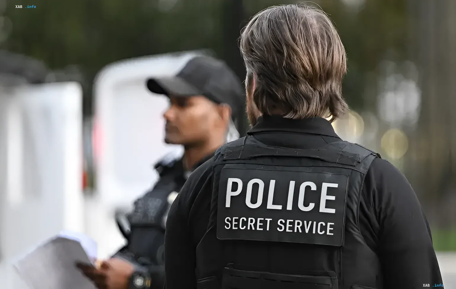 Agent der US-Secret Service in taktischer Weste mit Aufschrift 'POLICE SECRET SERVICE' während verstärkter Sicherheitsvorbereitungen für ein Trump-Veranstaltung