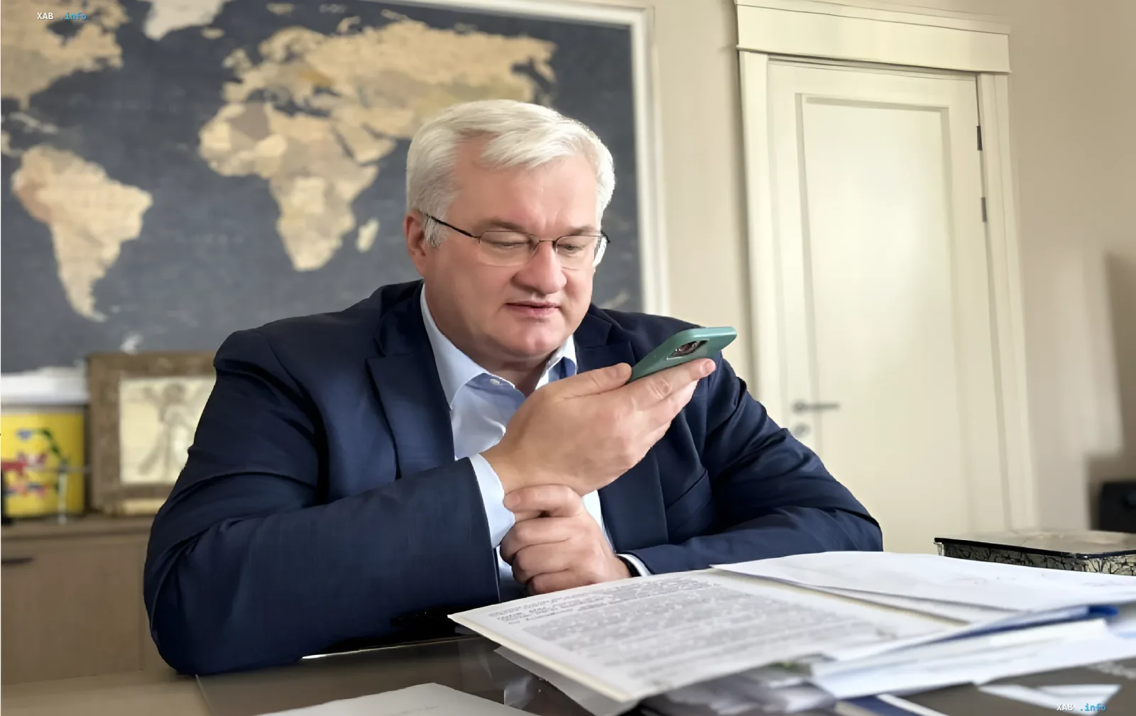 Андрей Сибига, министр инфраструктуры Украины, рассматривает данные на смартфоне в офисе, обсуждая атаки России на торговые суда в Черном море.