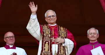 Papst Leo XIV in roter Mitra und goldenem Mantel begrüßt die Gläubigen, was die Urheberschaft der Enzyklika über das KI-Paradoxon symbolisiert