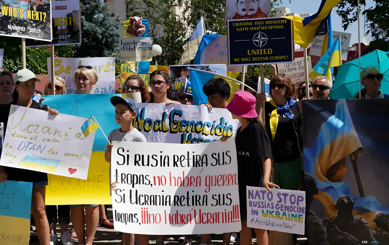 Pro-Ukraine-Demonstration in Spanien: Menschen halten Plakate mit Aufrufen zum Schutz und zur Solidarität, was die aktive Beteiligung von Ukrainern in der spanischen Gesellschaft und die Relevanz der neuen Reform zur Aufenthaltserlaubnis veranschaulicht.