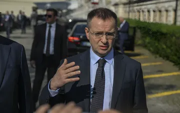 Wladimir Medinsky in einem Anzug und Brille, gestikulierend während eines Gesprächs mit der Presse auf der Straße