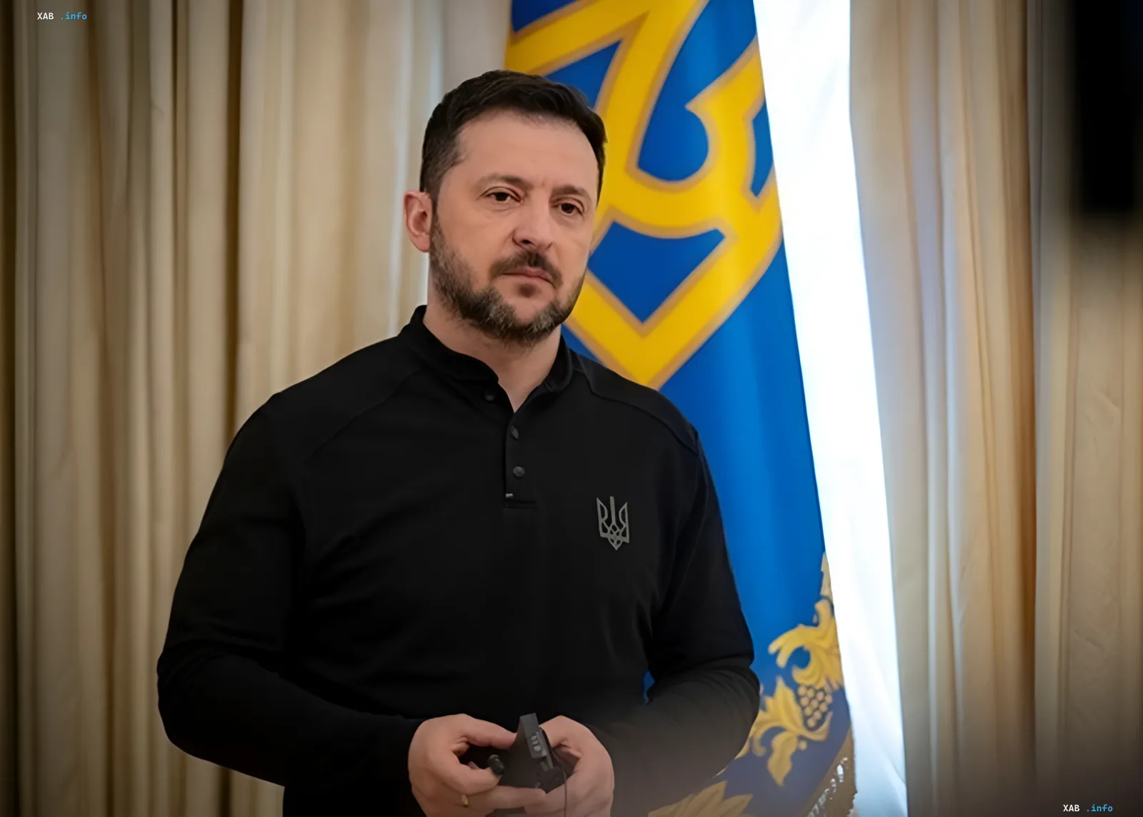Президент Украины Владимир Зеленский в черной рубашке с гербом, стоящий перед украинским флагом, предупреждает о блокаде зерновых коридоров