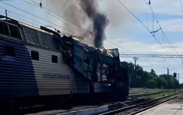 Сгоревший локомотив пассажирского поезда после атаки дрона в Днепропетровской области, черный дым поднимается в небо