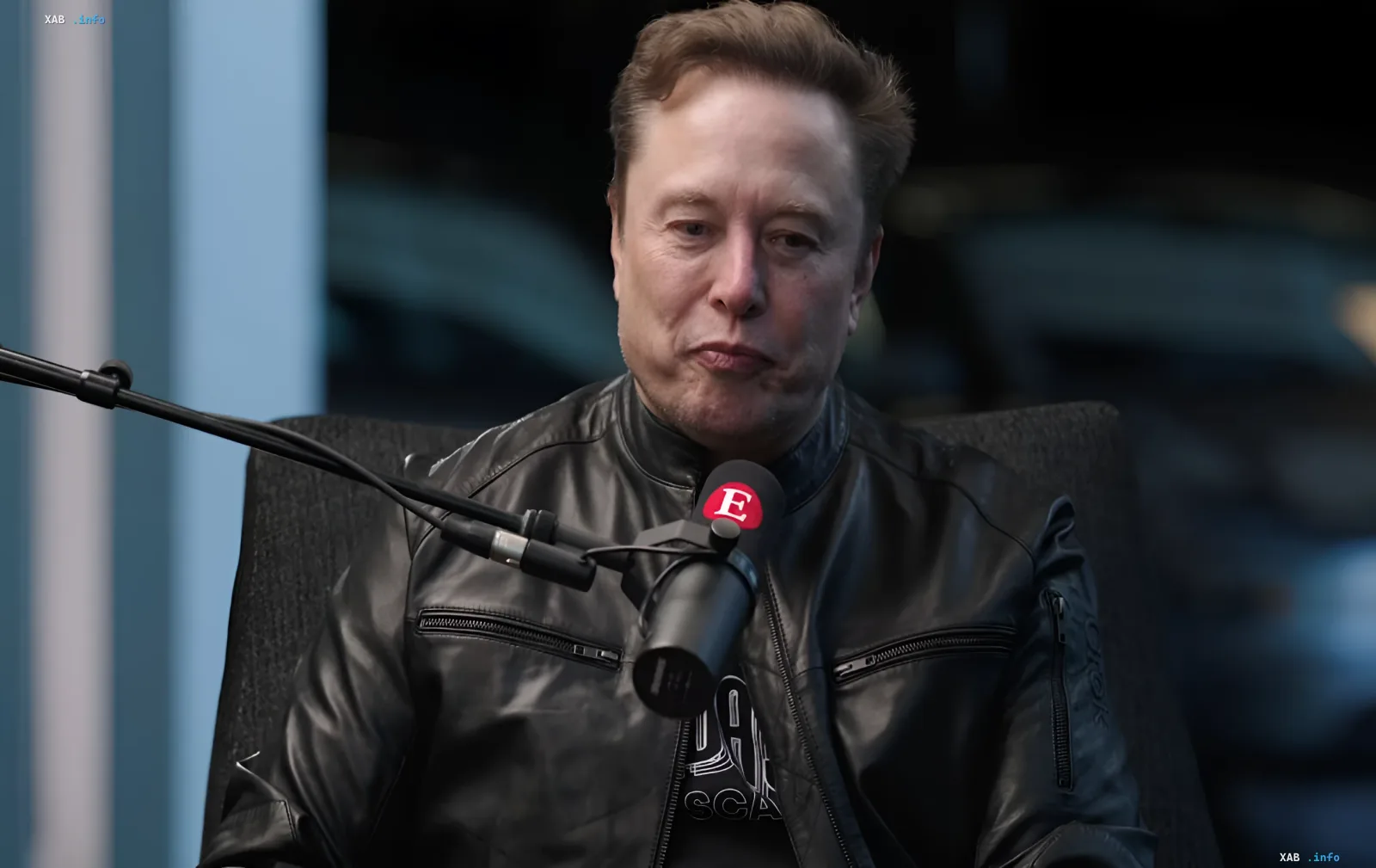 Elon Musk in einer Lederjacke während eines Interviews, diskutiert die Zukunft von Geld und Humanoiden