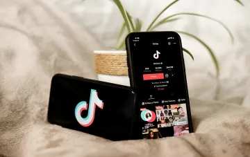 Два смартфона с открытым приложением TikTok на экране, символизирующие проблему защиты детей в соцсетях по версии Еврокомиссии