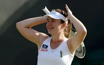 Дарья Снигур с улыбкой празднует исторический выход в полуфинал турнира WTA в Праге, держа ракетку за спиной