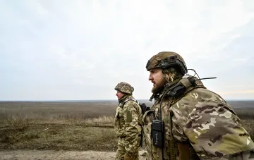 Ukrainische Soldaten in Tarnanzug mit Funkgeräten vor einer Steppe — Symbol für neue Infanterie-Sturmverträge der Streitkräfte der Ukraine