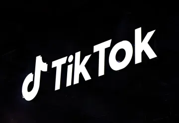 Логотип TikTok на темном фоне: социальная сеть сталкивается с новыми штрафами и регуляторным давлением в Европе и Южной Корее