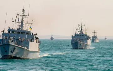 Українські військові кораблі під прапорами України та НАТО в строю на морі — символ нового статусу командира Альянсу