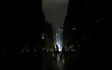 Silhouetten von Menschen, die auf einer dunklen Straße in Tiflis während eines massiven Stromausfalls in Georgien gehen
