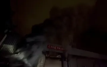 Feuerwehrleute löschen Feuer in einer riesigen Halle in Moskau, dichter Rauch und Rettungsaktion sichtbar