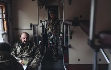 Военнослужащие в камуфляжной форме в вагоне поезда Укрзализныци, иллюстрирующие упрощенный процесс покупки билетов через Армия+