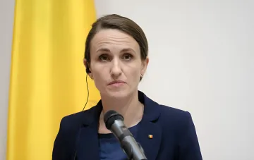 Румынский министр иностранных дел в ходе пресс-конференции на фоне флага Румынии, комментируя инцидент с российскими дронами и вызов российского посла