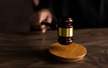 Судебный молоток на деревянном столе, символизирующий конфискацию активов россиян в Украине
