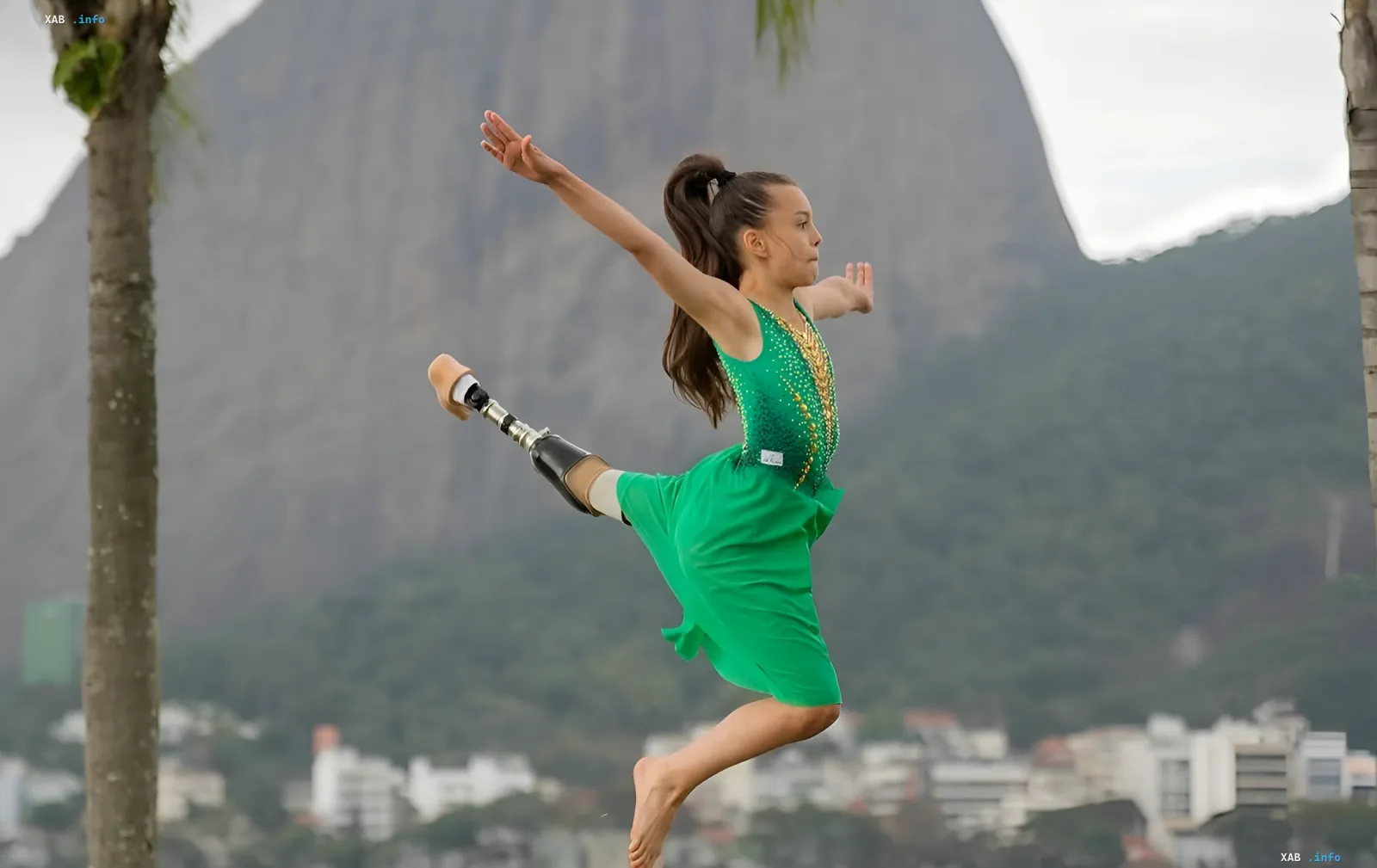 10-year-old gymnast with leg prosthetic in green leotard performs leap against Rio de Janeiro mountain backdrop — symbol of 'Dance of Freedom' tour that wowed Ronaldinho