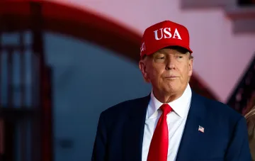 Donald Trump in einer roten Kappe mit der Aufschrift USA, die die amerikanische Politik und den möglichen Mangel an Patriot-Raketen symbolisiert