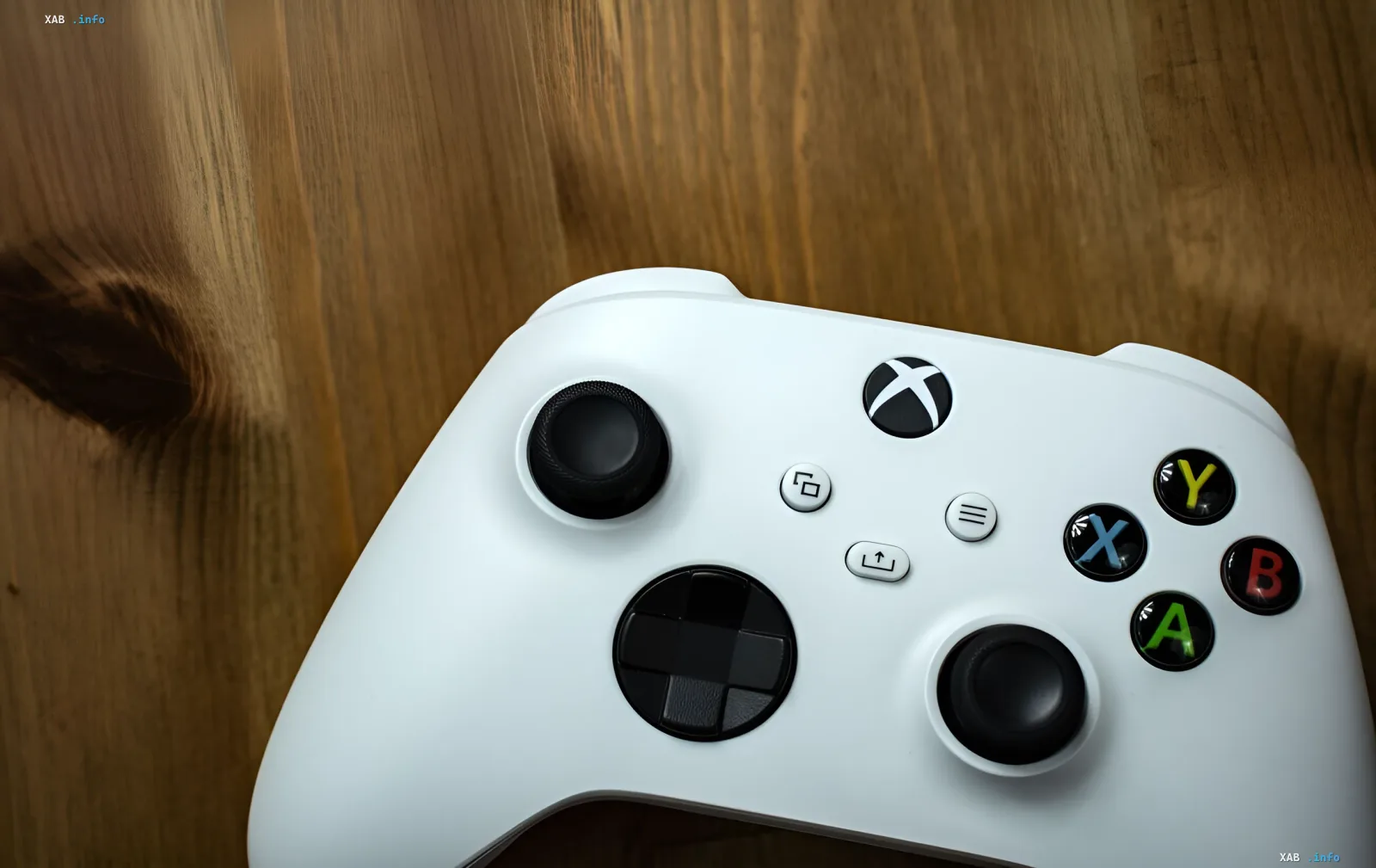 Белый геймпад Xbox на деревянном столе — символ глобального сбоя, оставившего миллионы игроков без доступа к играм